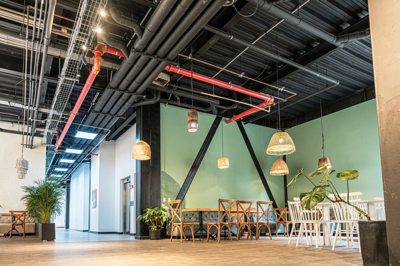 hotel con restaurante en Bogotá de Nova Iorque con mesas, sillas, lámparas tejidas y techo industrial