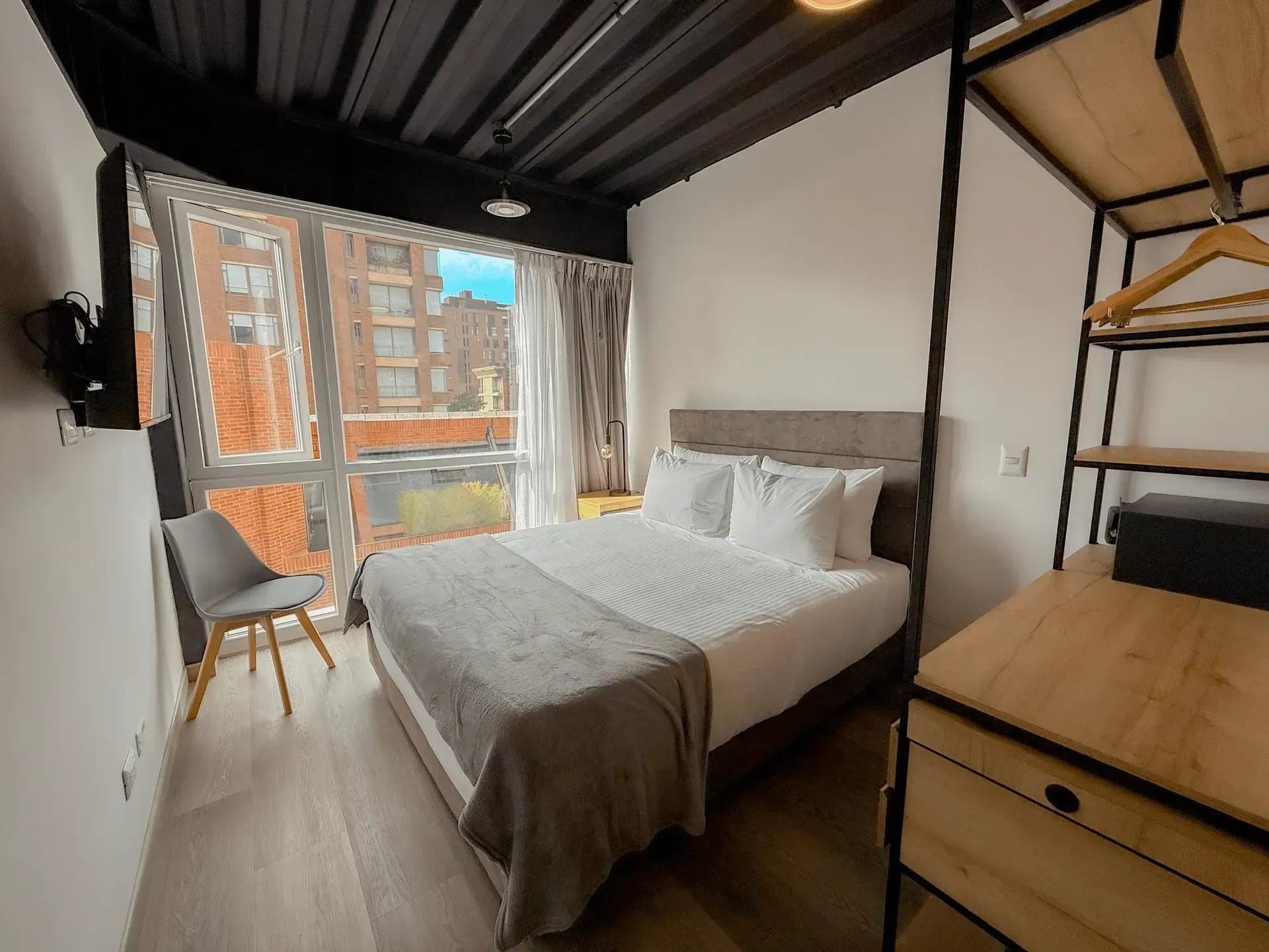 apartahotel en bogotá, con cama doble, televisor, cocina equipada y vista a la ciudad