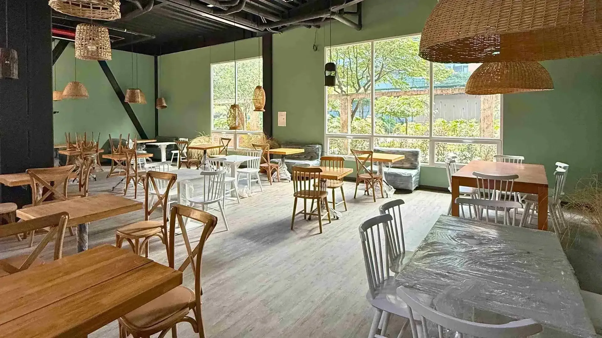 Restaurante con mesas de madera, sillas y ventanales amplios en Nova Iorque Suites, hotel en Bogotá para noches románticas.