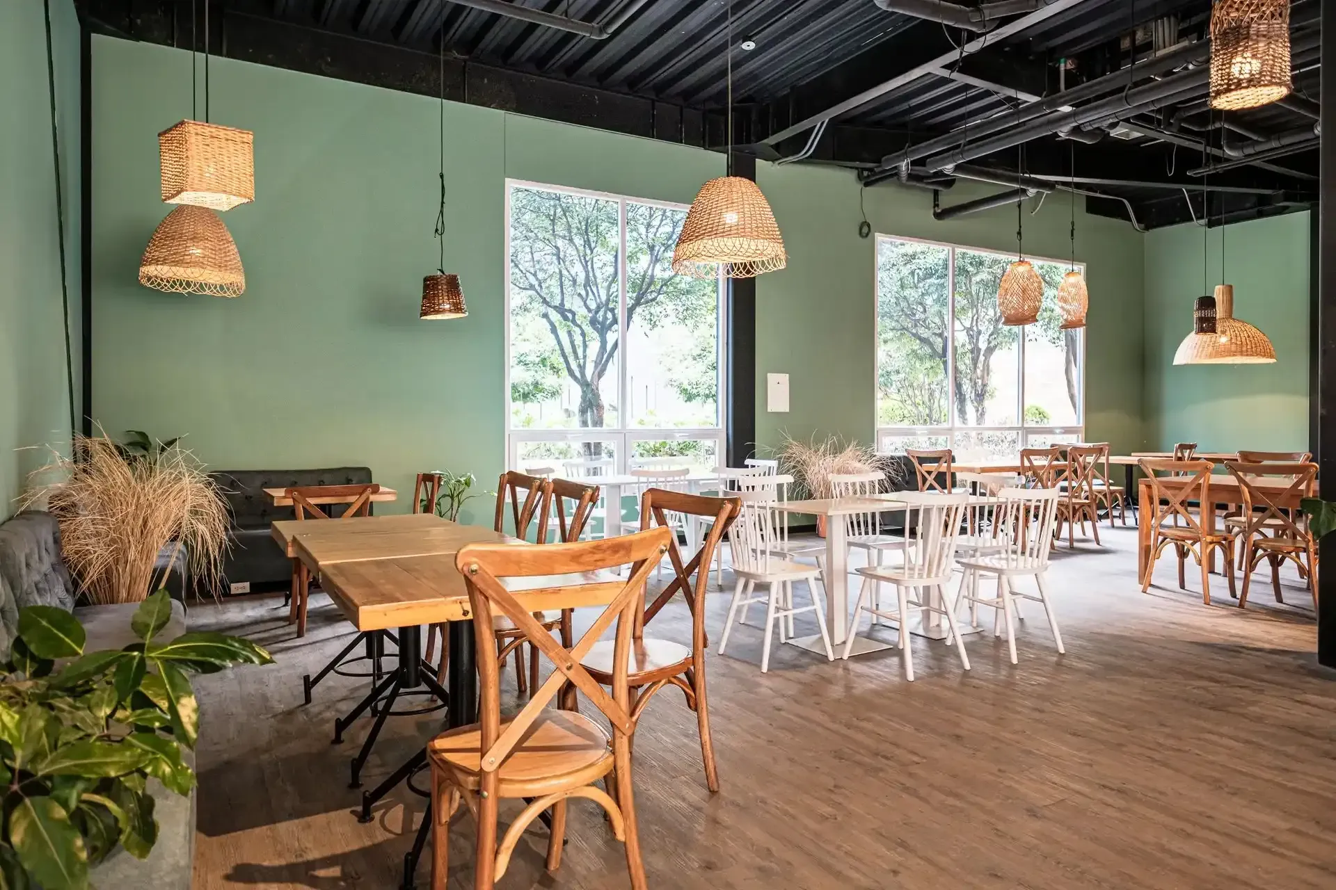 Hotel with restaurant in Bogotá, featuring wooden tables, chairs, and decorative plants in a warm setting.