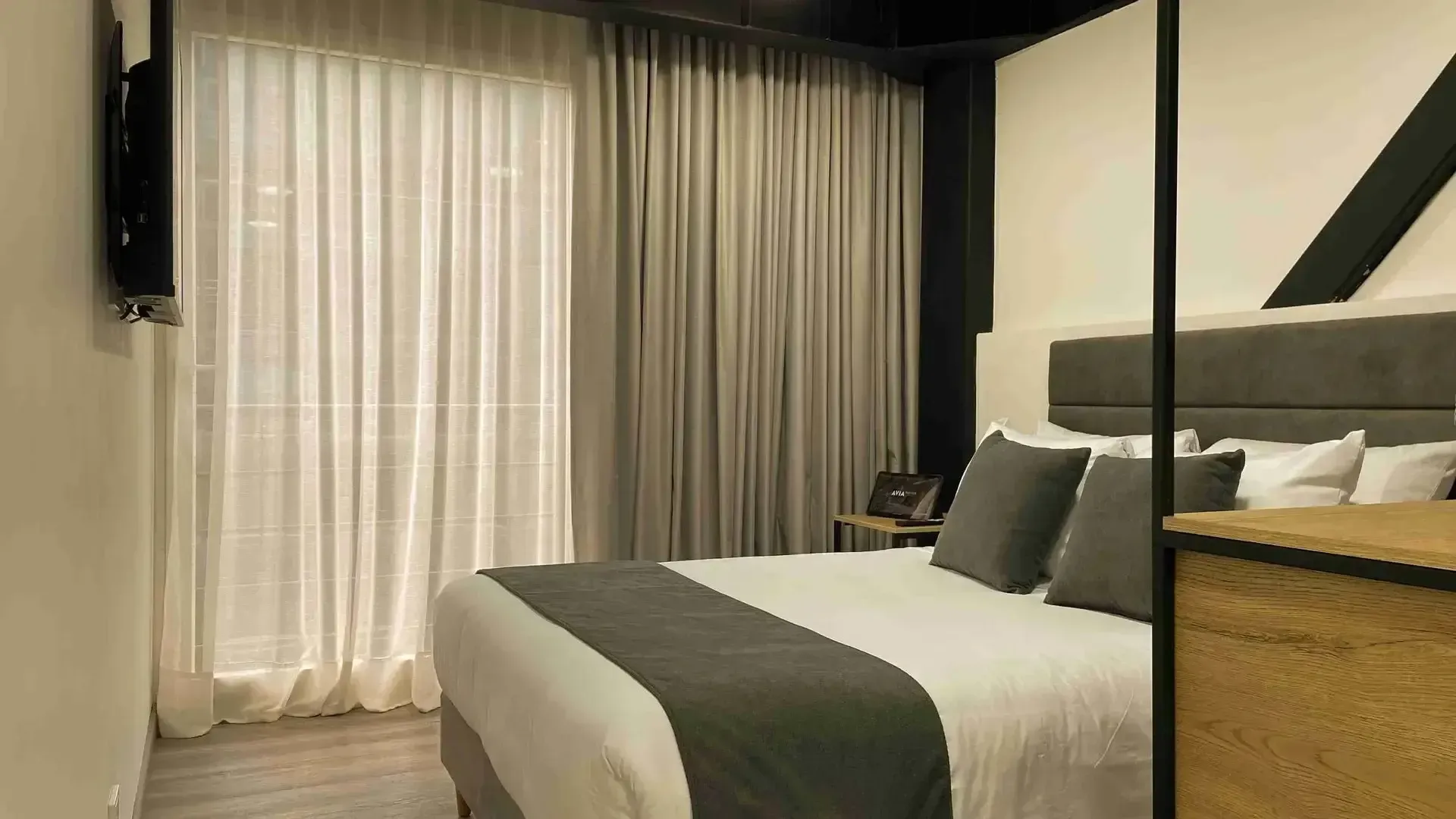 Apartasuites en Bogotá, con habitación de cama doble, cortinas amplias y diseño interior moderno en Nova Iorque