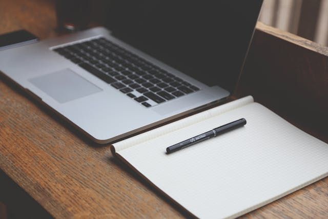 A laptop and open notebook with a pen suggest quiet planning and support through Roanoke, VA funeral services