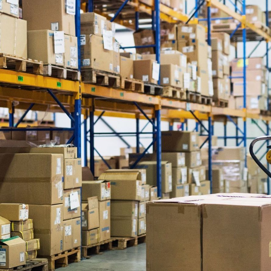 Warehouse shelves stacked with cardboard boxes and pallets in storage aisles