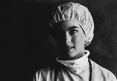 A black and white photo of a nurse wearing a surgical cap.