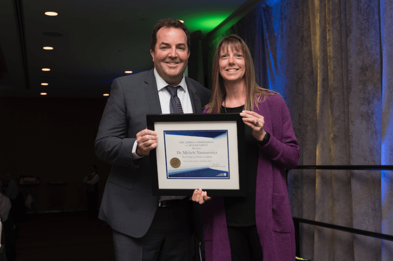 A man and a woman are holding a framed certificate.