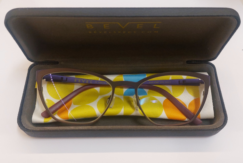 A pair of glasses in a case that says bevel