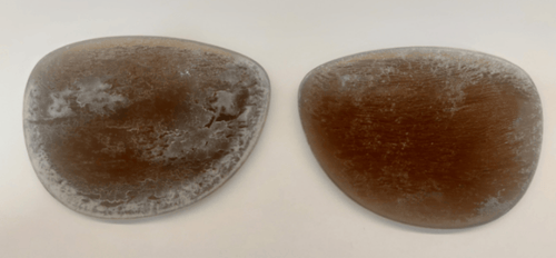 Two brown, oval-shaped lenses damaged due to bug spray.