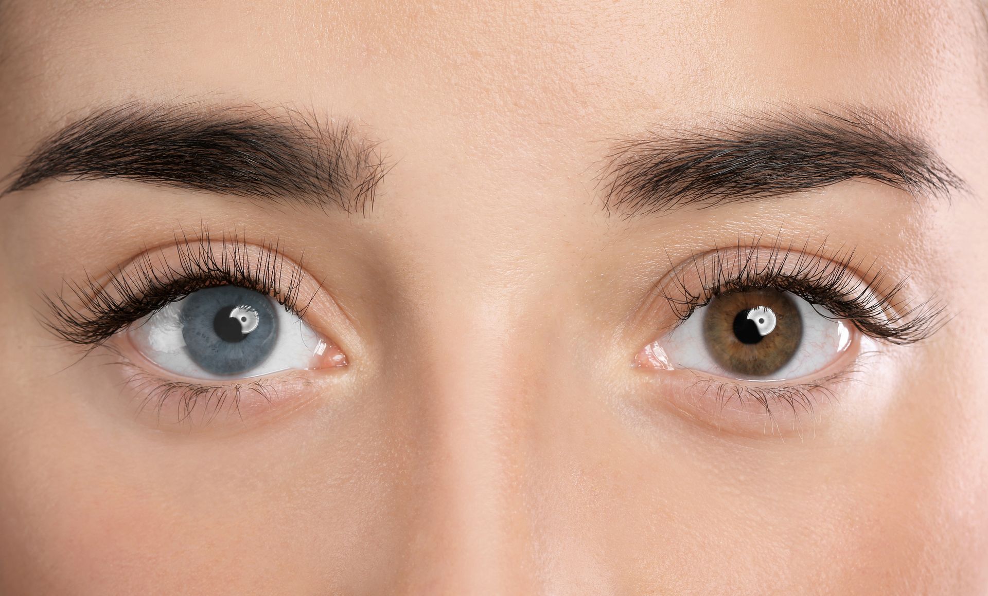 A close up of a woman 's blue and brown eyes.