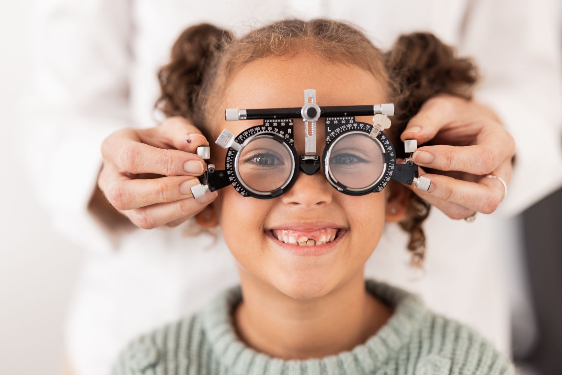 A little girl is getting her eyes checked by an ophthalmologist.