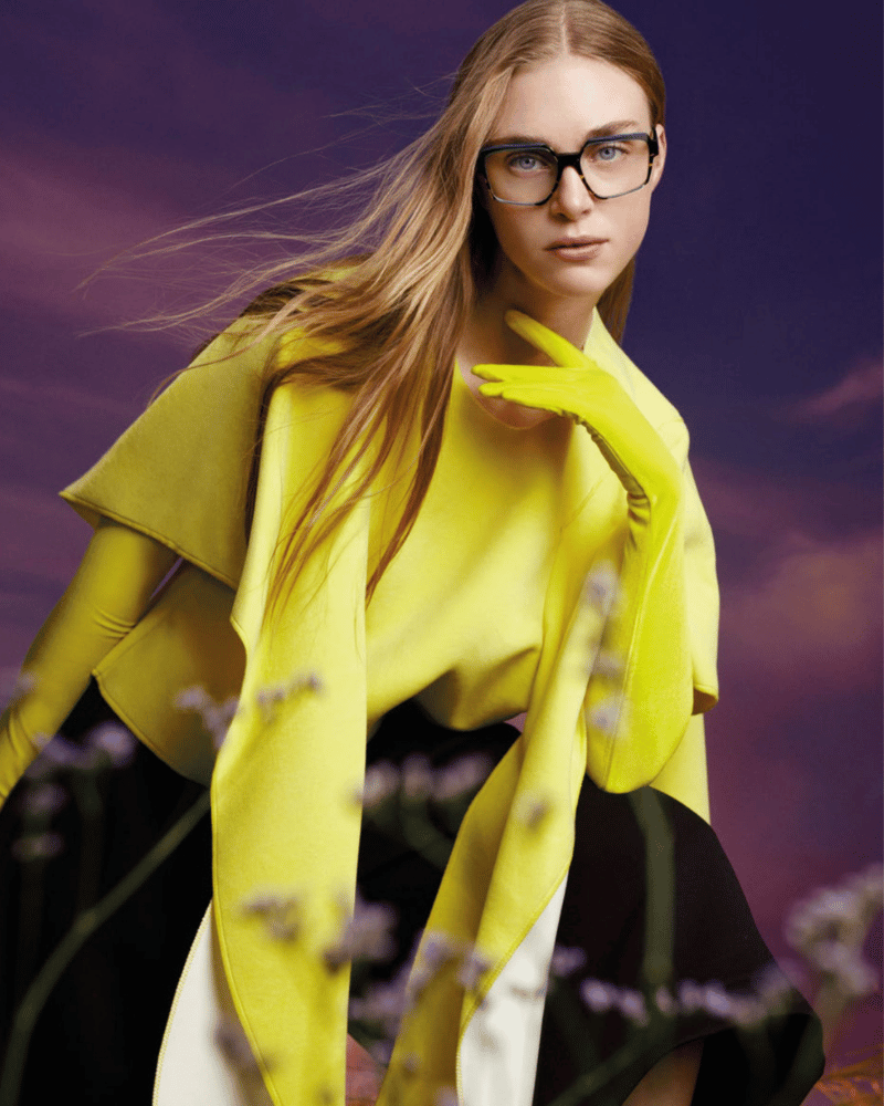 A woman wearing glasses and a yellow coat