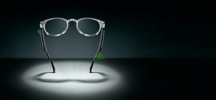 Pair of eyeglasses standing upright under a spotlight on a dark background