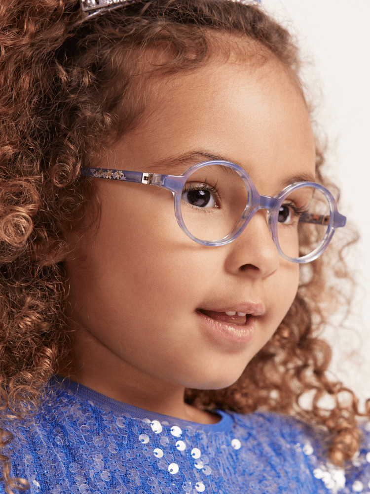 A little girl wearing glasses and a blue dress.