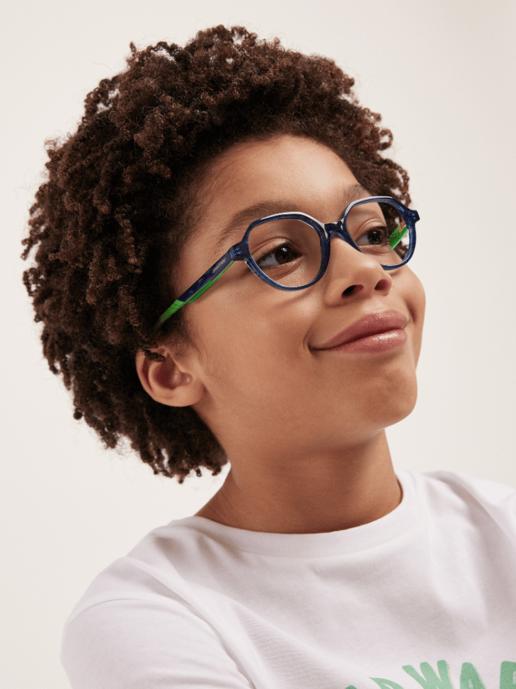 A young boy wearing glasses and a white shirt