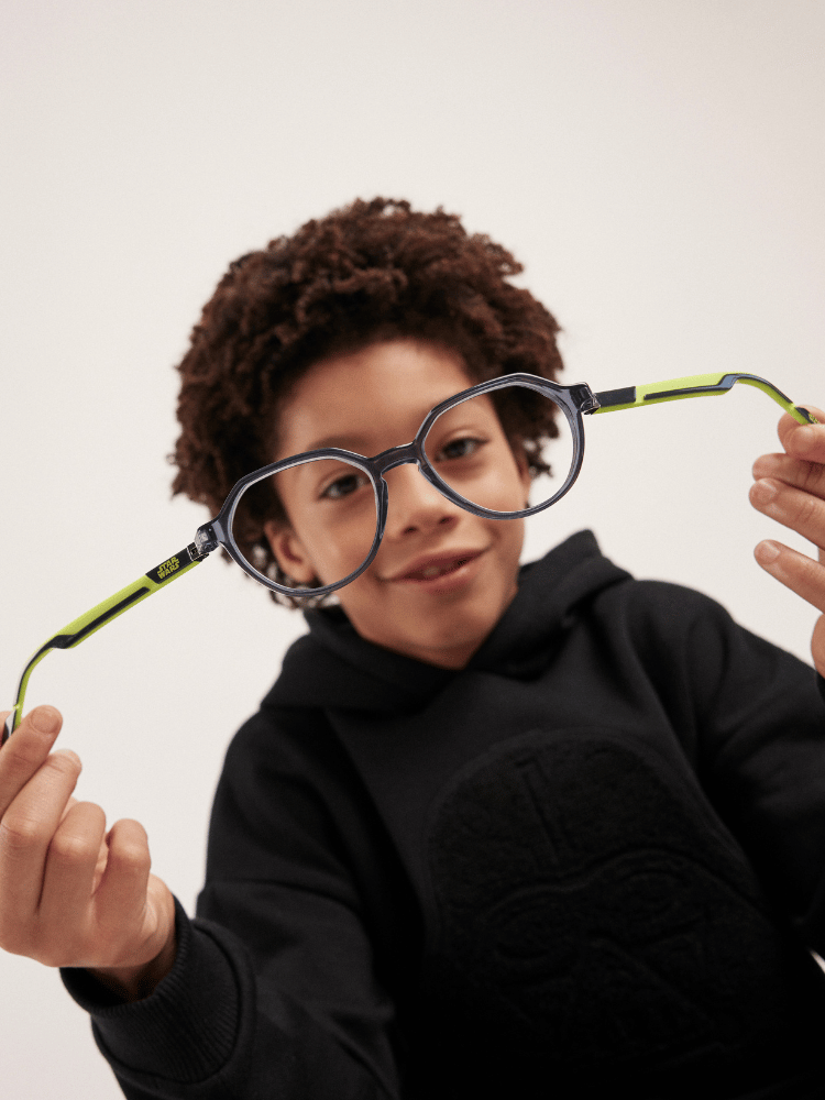 A young boy wearing glasses and a black hoodie