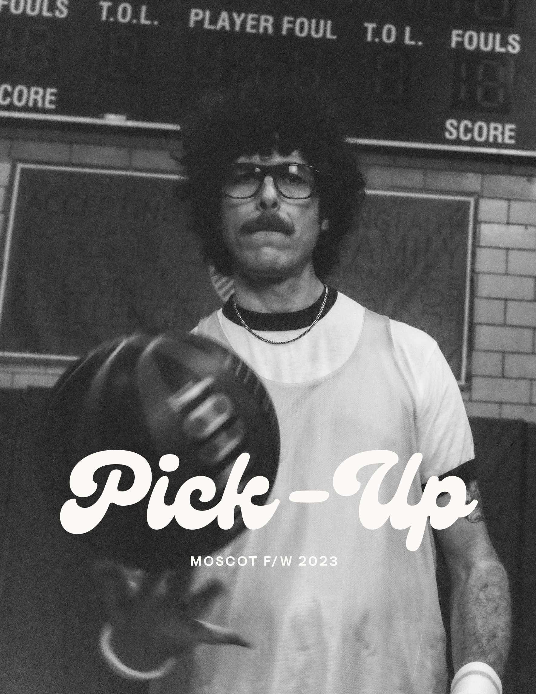 A man holding a bowling ball in front of a scoreboard that says pick up