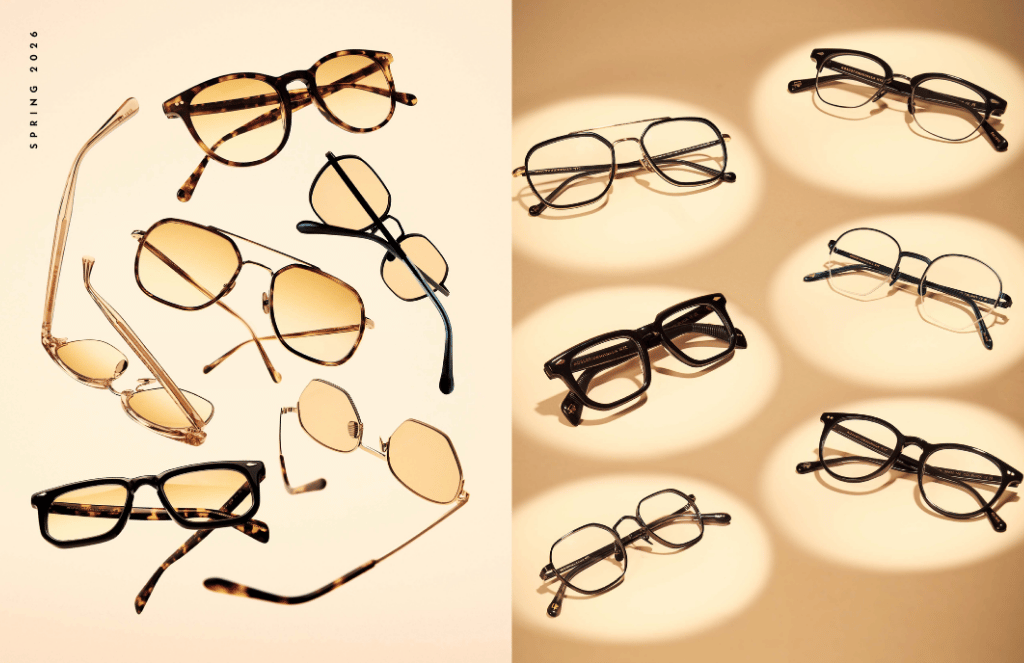 Assorted eyeglasses with gold, black, and brown frames arranged on a warm beige background