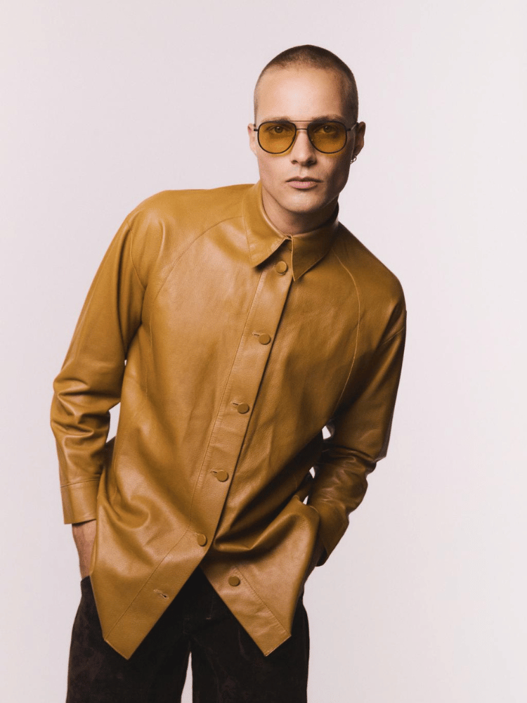 A man wearing sunglasses and a brown leather shirt