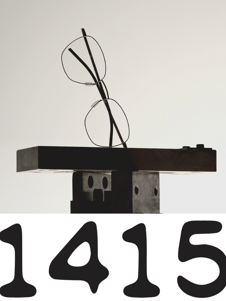 A pair of glasses sitting on top of a shelf next to the number 1415