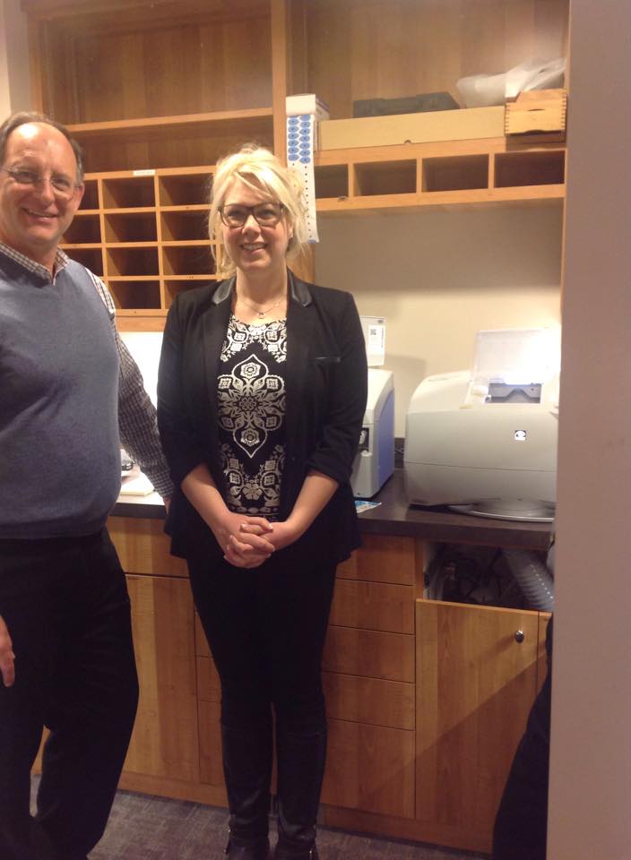 A man and a woman are standing next to each other in a kitchen