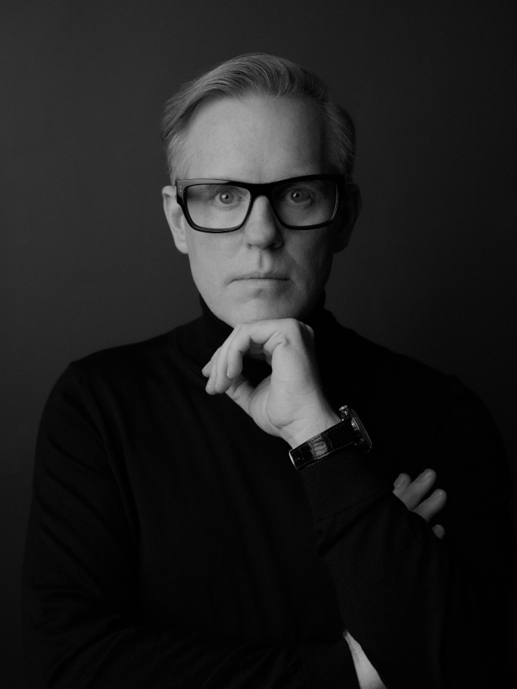 A black and white photo of a man wearing glasses and a turtleneck.