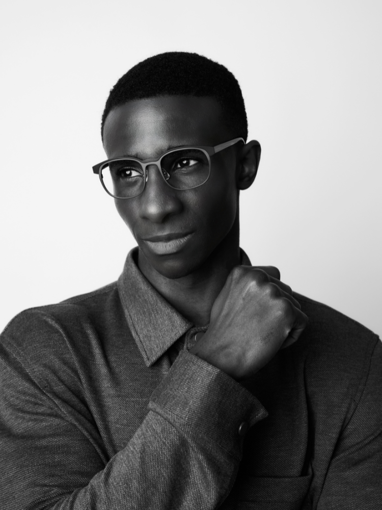 A black and white photo of a man wearing glasses