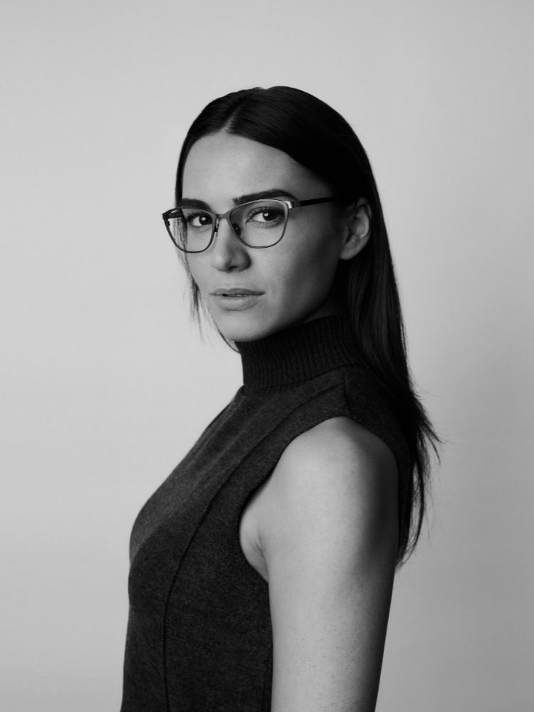A black and white photo of a woman wearing glasses and a turtleneck.