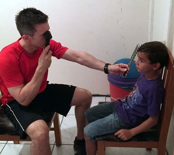 A man in a red shirt is talking to a young boy in a purple shirt
