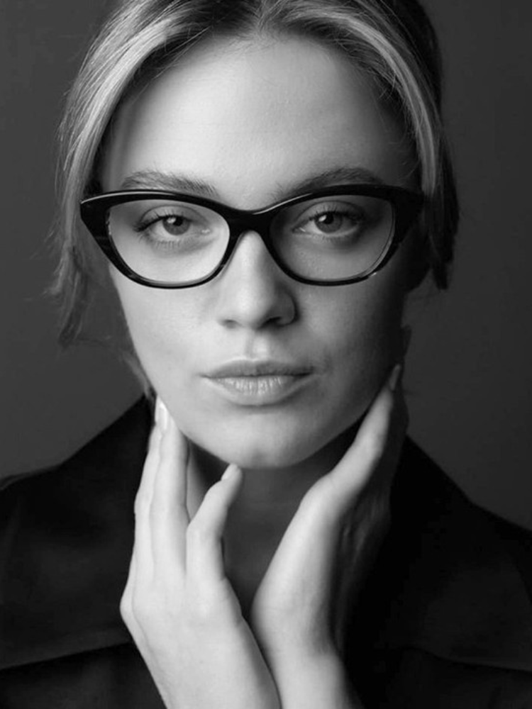 A black and white photo of a woman wearing glasses.