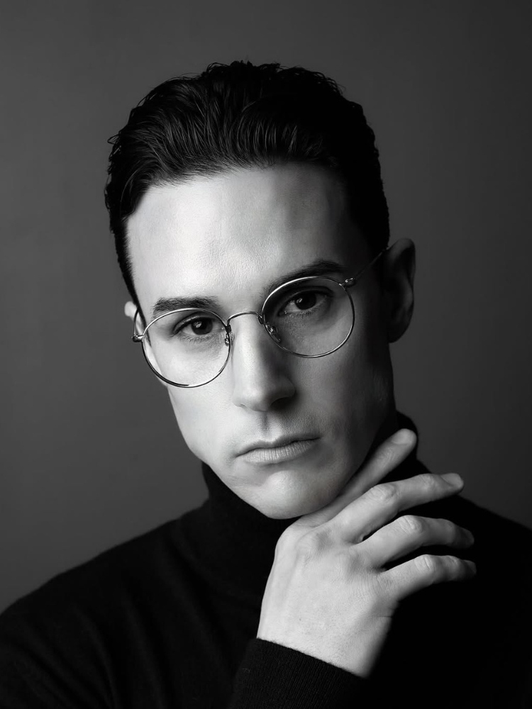 A black and white photo of a man wearing glasses and a turtleneck.