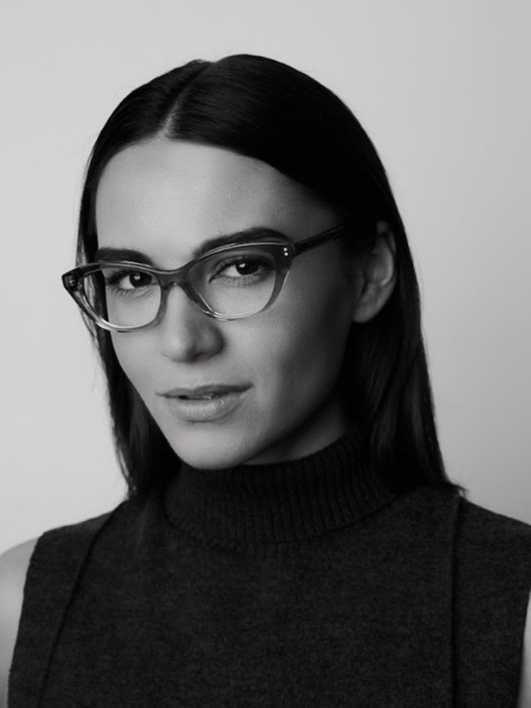 A black and white photo of a woman wearing glasses and a turtleneck.