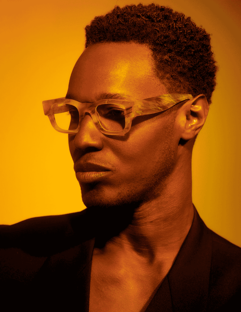 A close up of a man wearing glasses and a black jacket