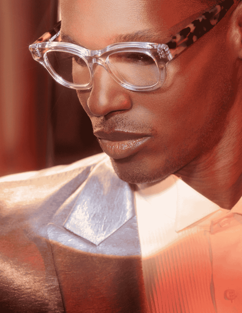 A close up of a man wearing glasses and a suit.