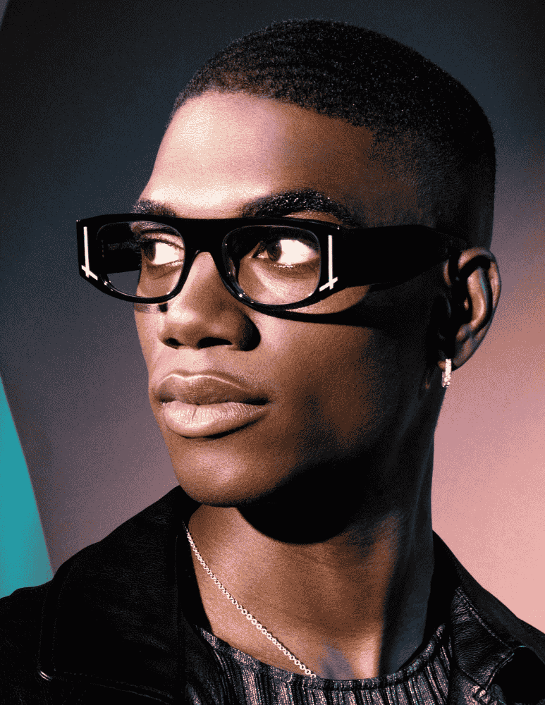 A close up of a man wearing glasses and a leather jacket