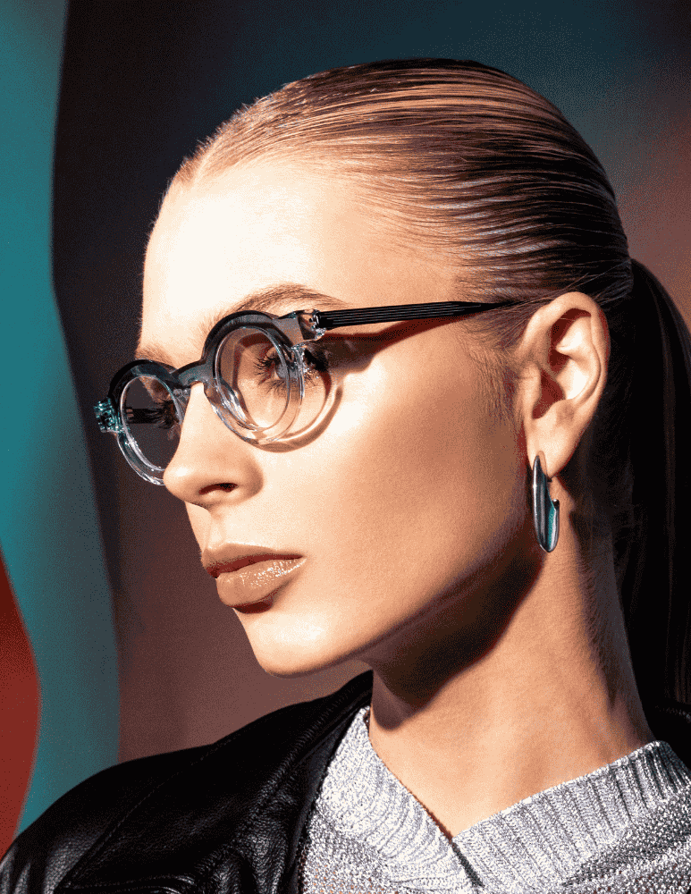 A close up of a woman wearing glasses and earrings.