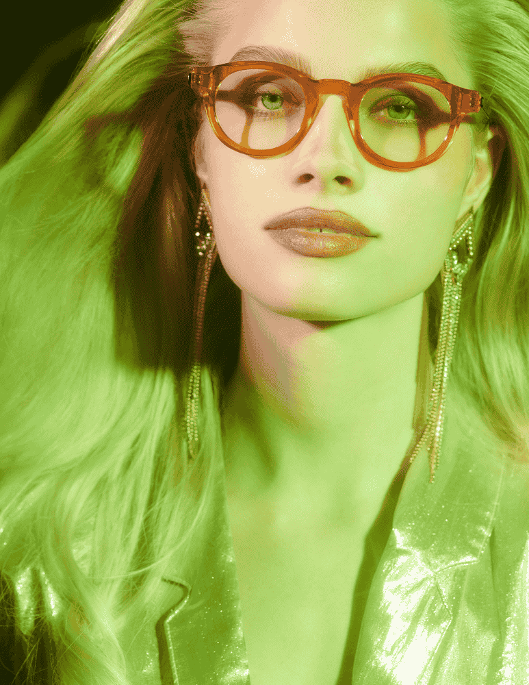 A close up of a woman wearing glasses and earrings.