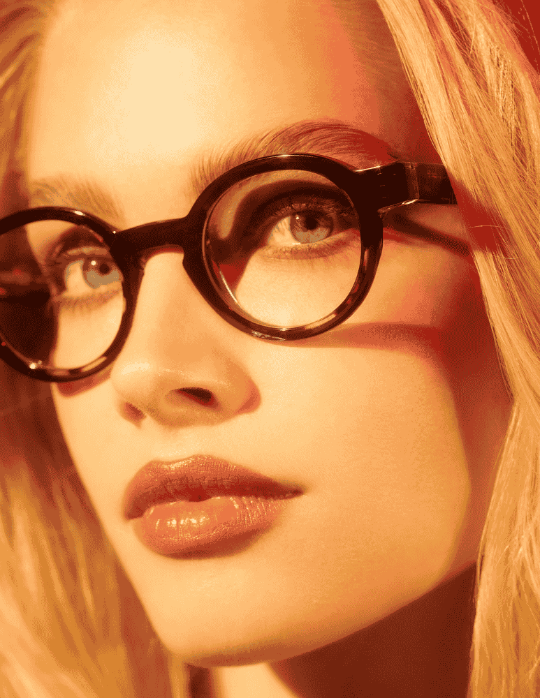 A close up of a woman wearing glasses and red lipstick.