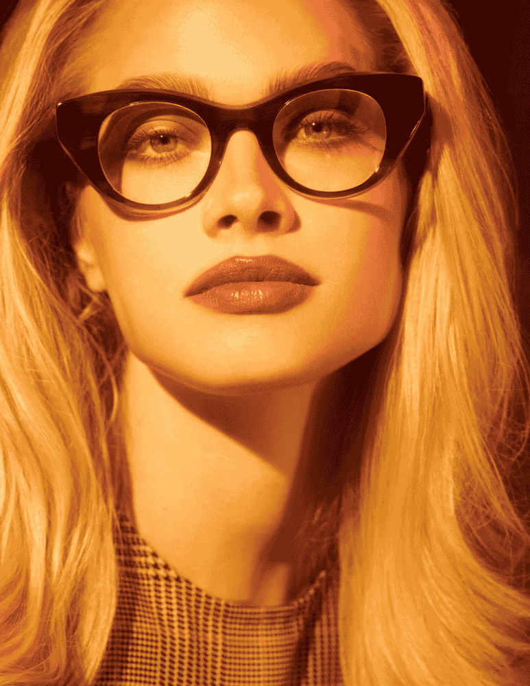 A close up of a woman wearing glasses and a plaid shirt.