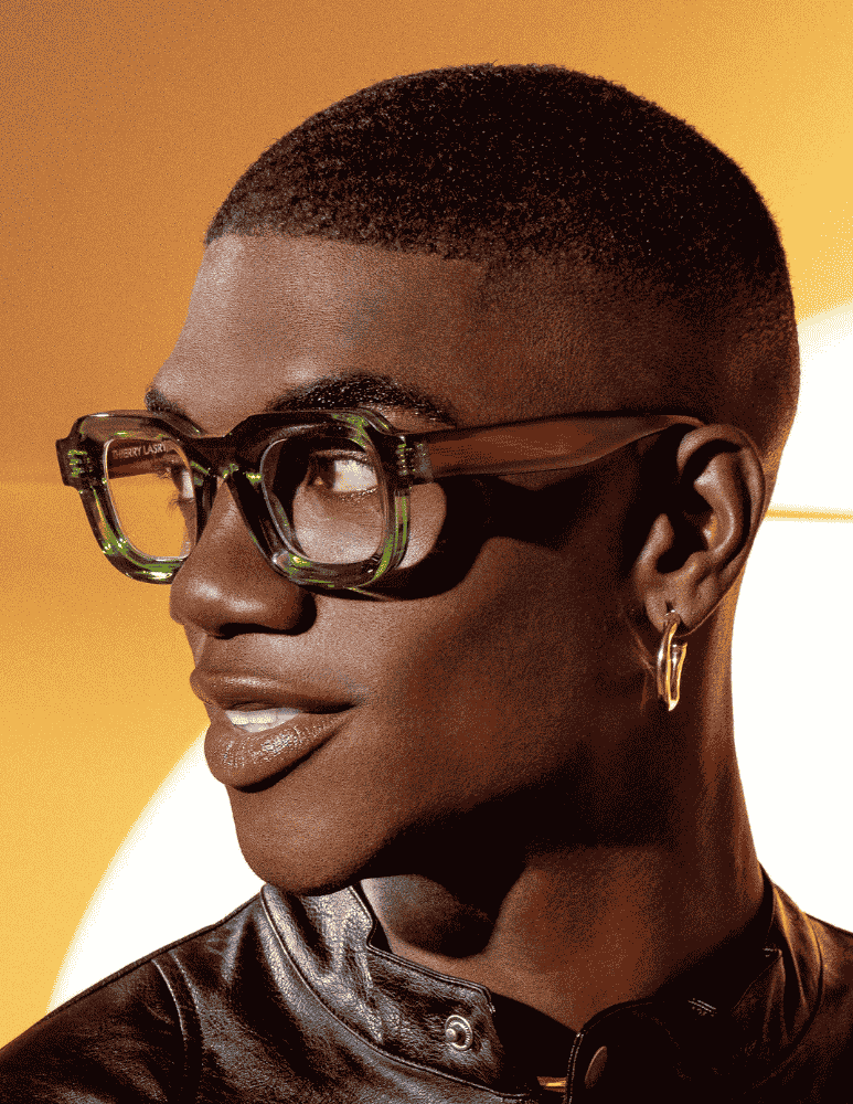 A close up of a man wearing glasses and earrings
