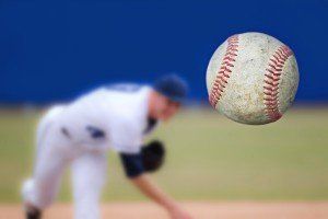 A baseball is being thrown in the air by a pitcher