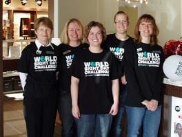 A group of women wearing world light day shirts are posing for a picture.