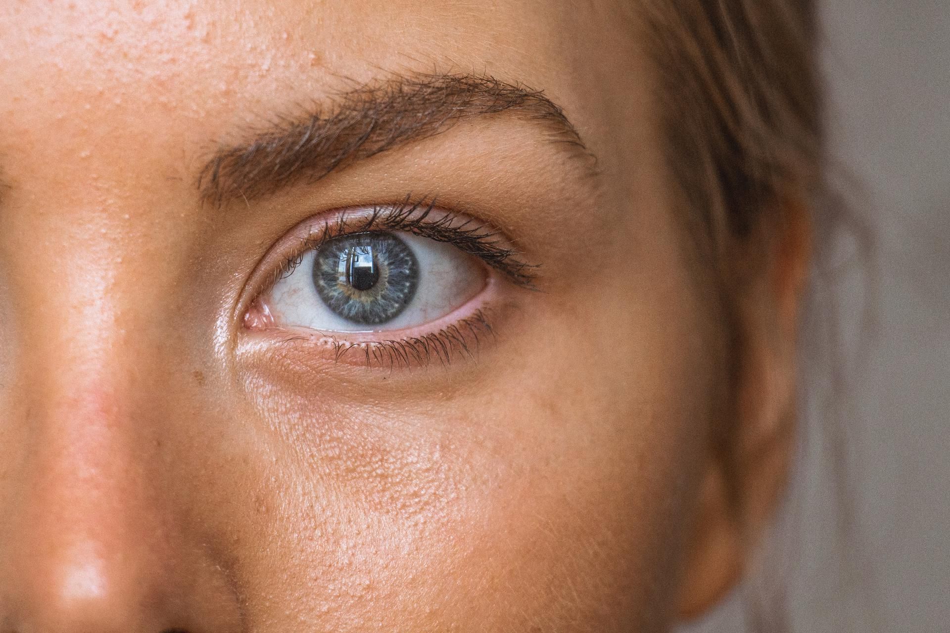 A close up of a woman 's face with a blue eye.