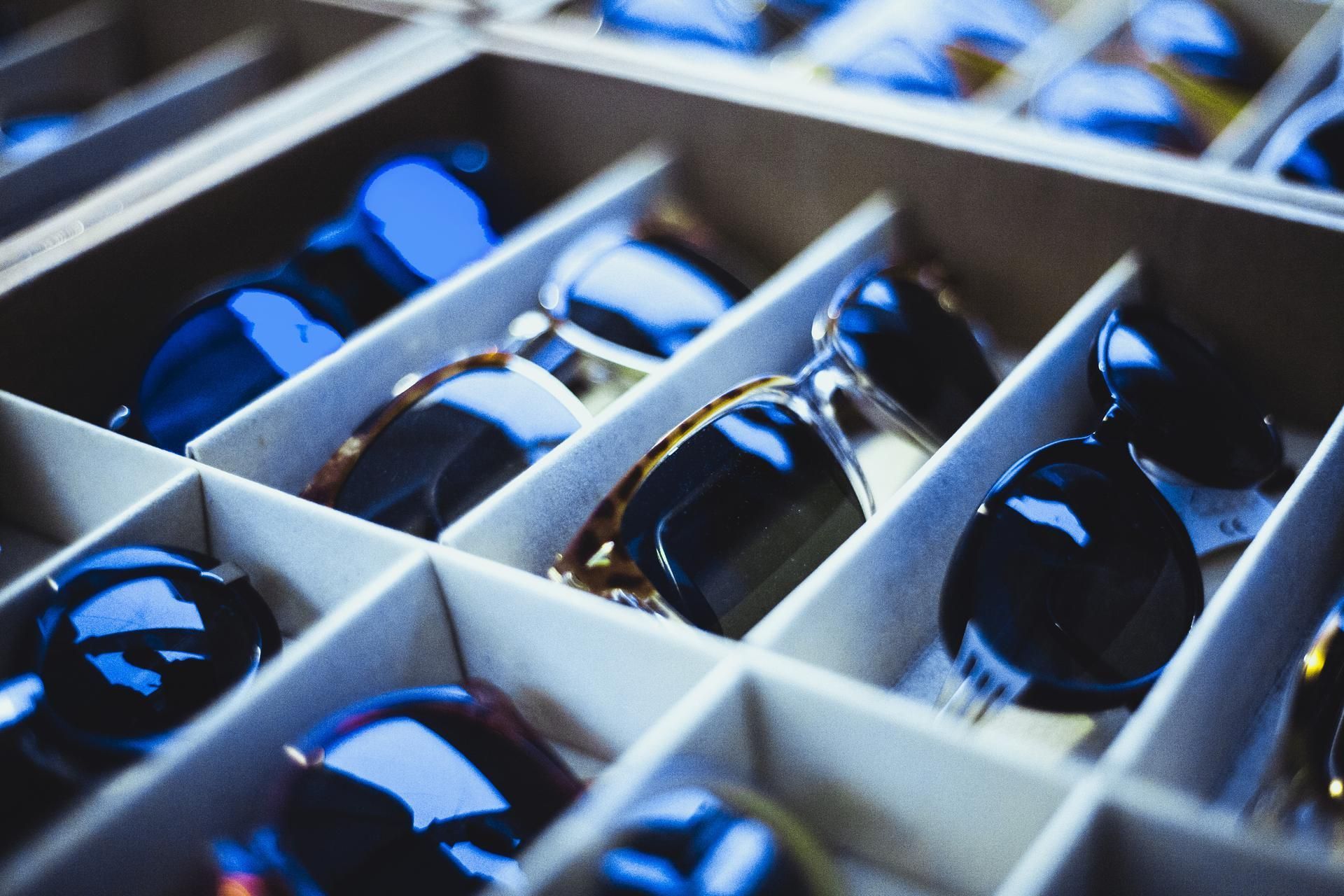 A box filled with many different types of sunglasses.