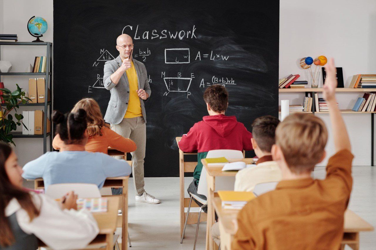A teacher is giving a lecture to a group of students in a classroom.