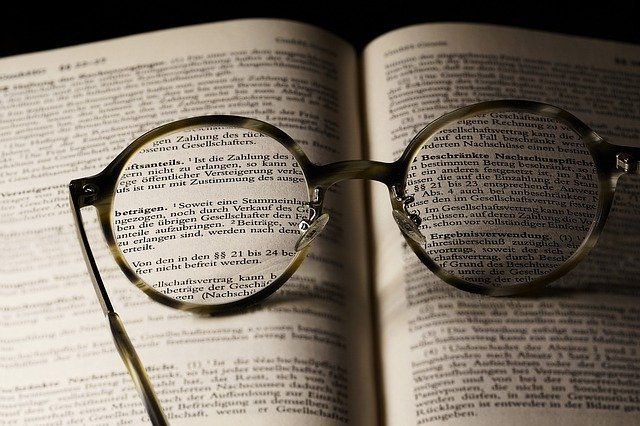 A pair of glasses sitting on top of an open book