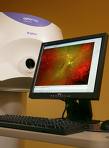 A computer monitor is sitting on top of a desk next to a machine.