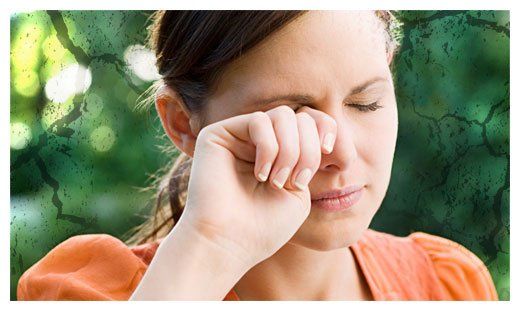 A woman is covering her eyes with her hand.