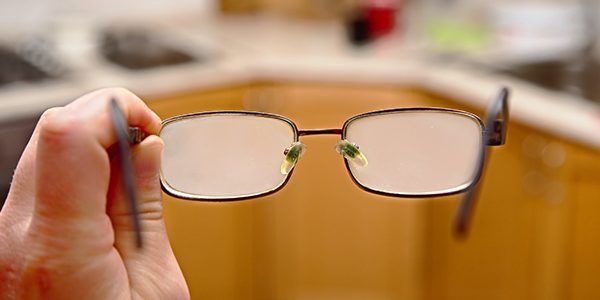 A person is holding a pair of glasses in their hand.