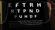 A person is holding a pair of glasses with letters on them.