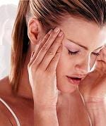 A woman is covering her face with her hands.