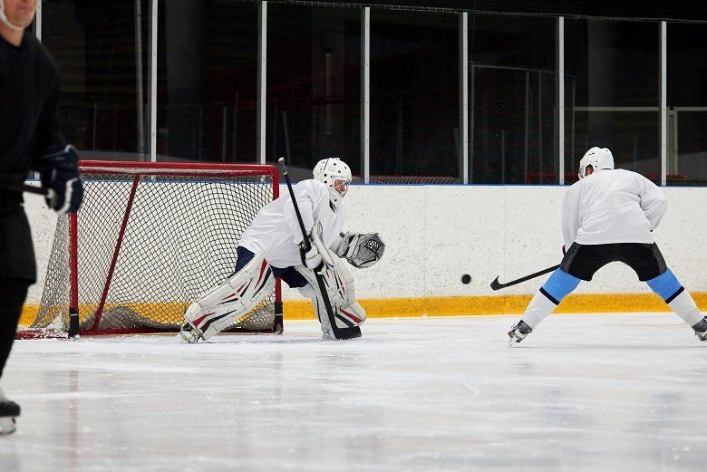 Two hockey players are playing a game of hockey on a rink.